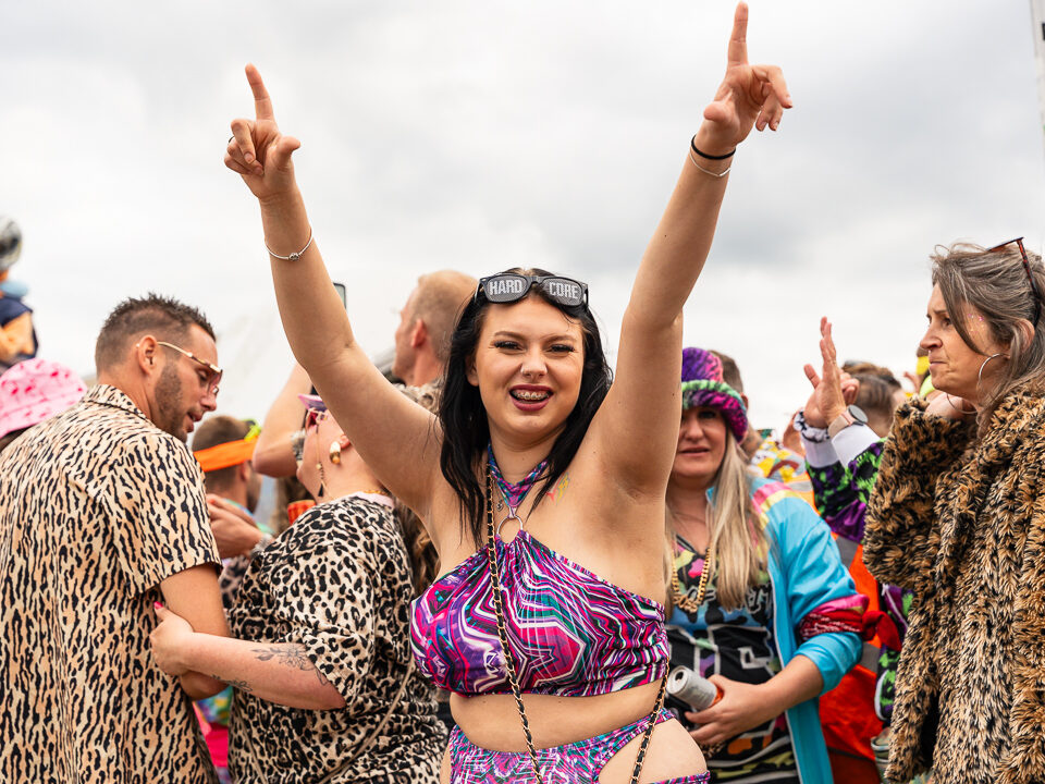 Juichende festivalbezoeker met haar armen omhoog op Kamping Kitsch Club