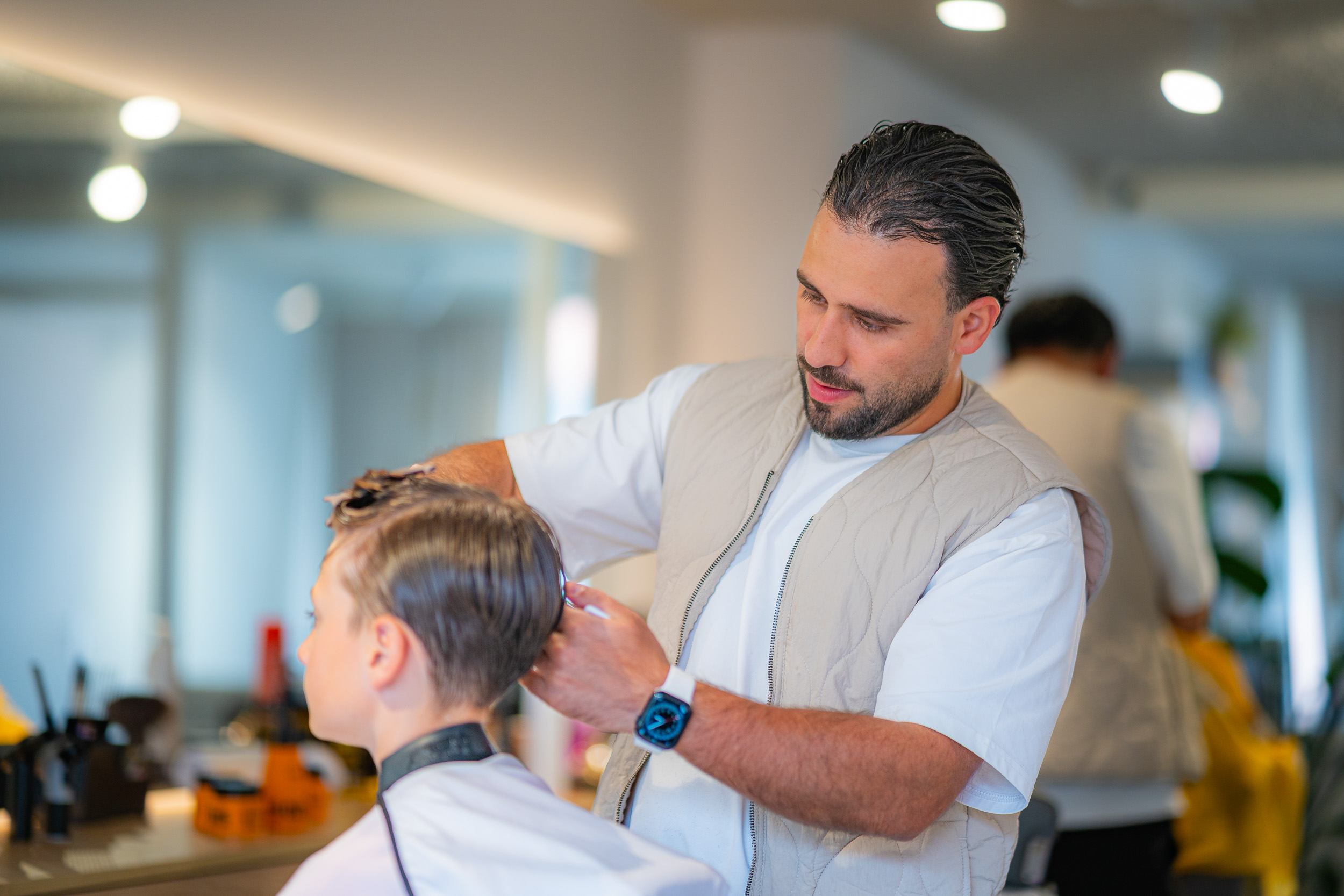 Barbier aan het werk tijdens een knipbehandeling in de barbershop