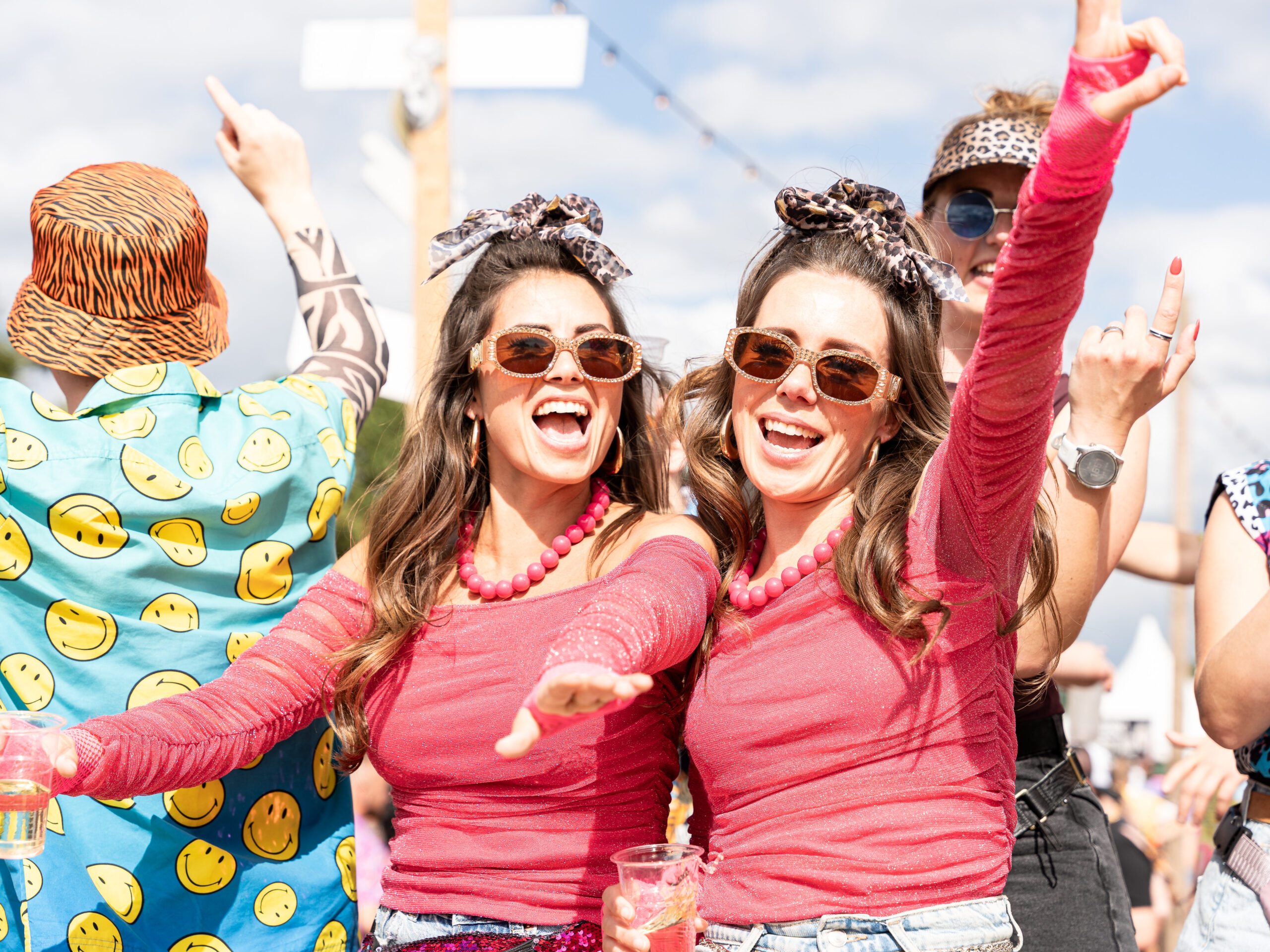 Twee festivalbezoekers in rood-roze outfits tijdens Kamping Kitsch Club